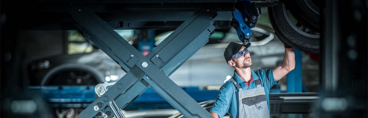 Mechanic under a vehicle doing repairs - Car Repairs Newport